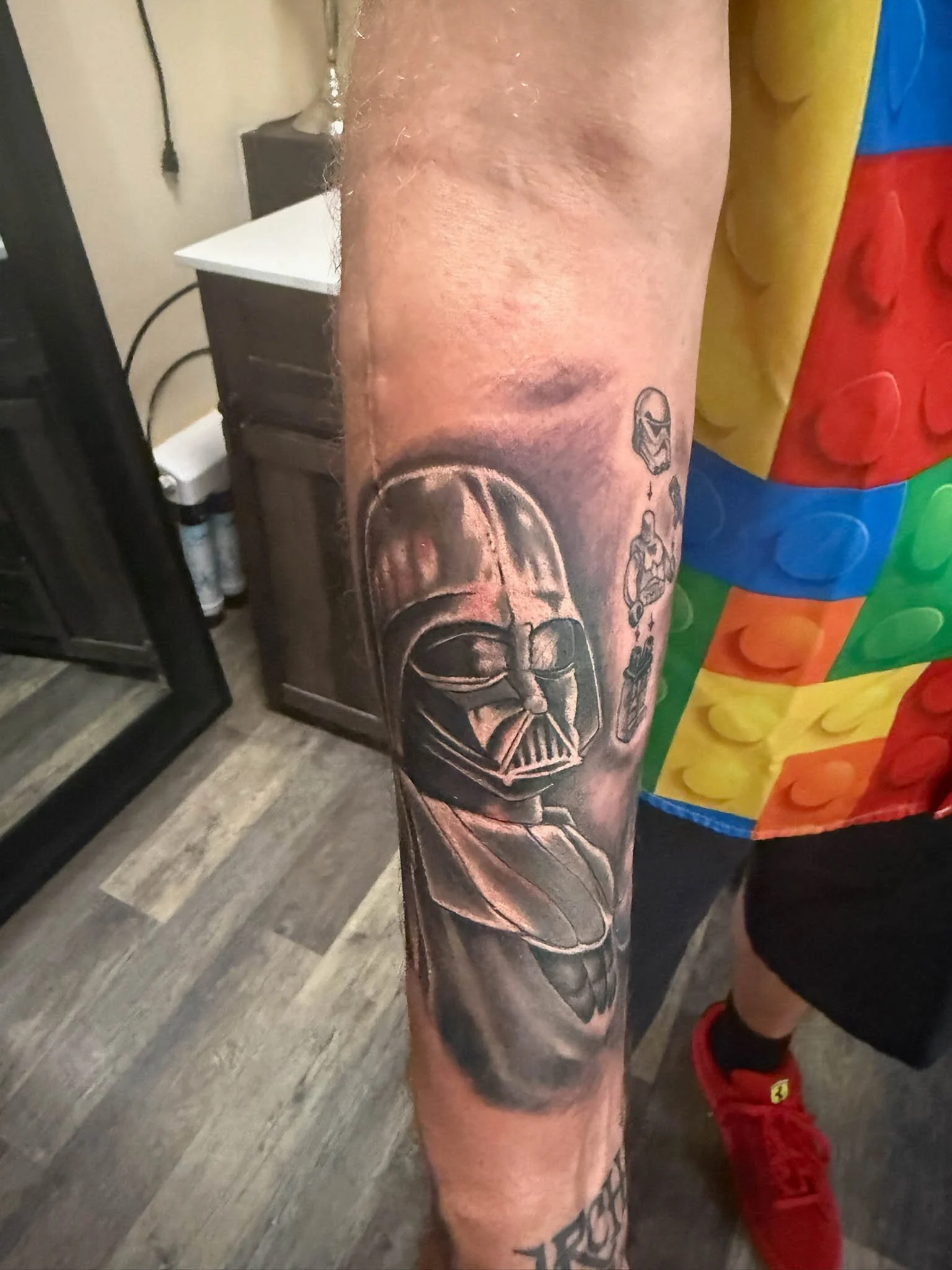 Tattoo of Darth Vader's helmet on a person's arm.