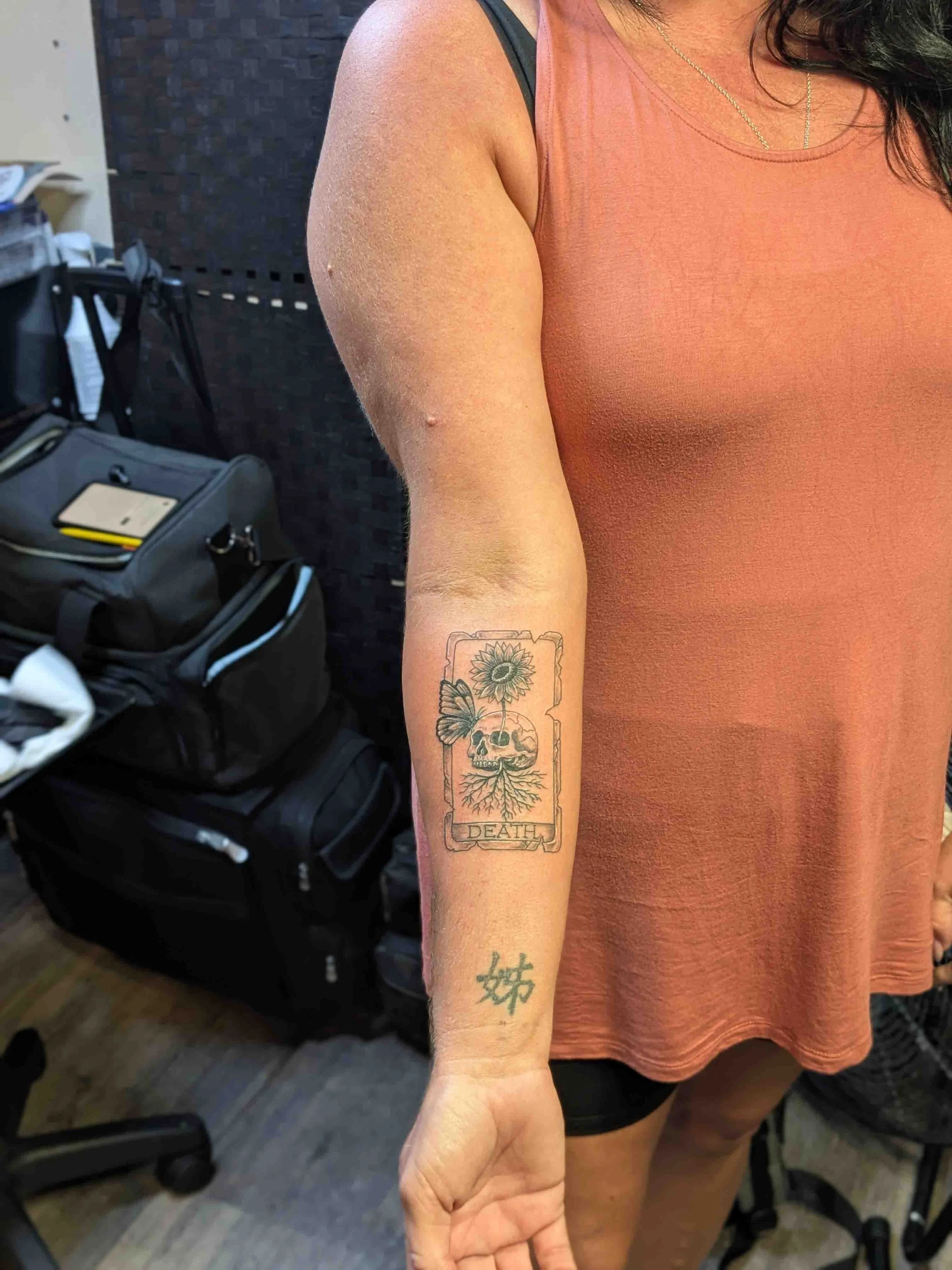 Inner tarot card forearm tattoo shown on a standing person
