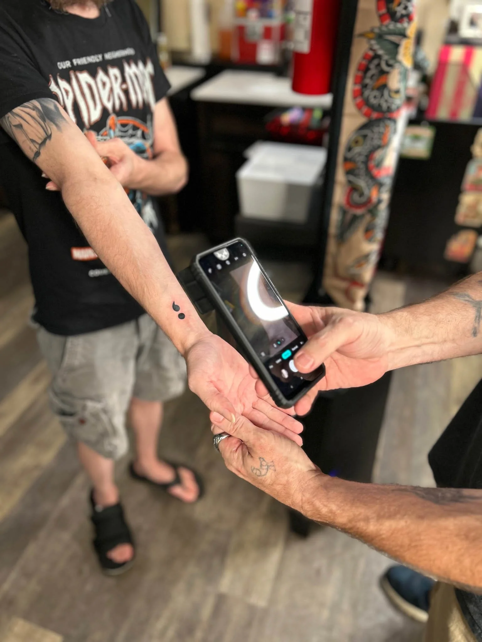 Black colon tattoo on wrist