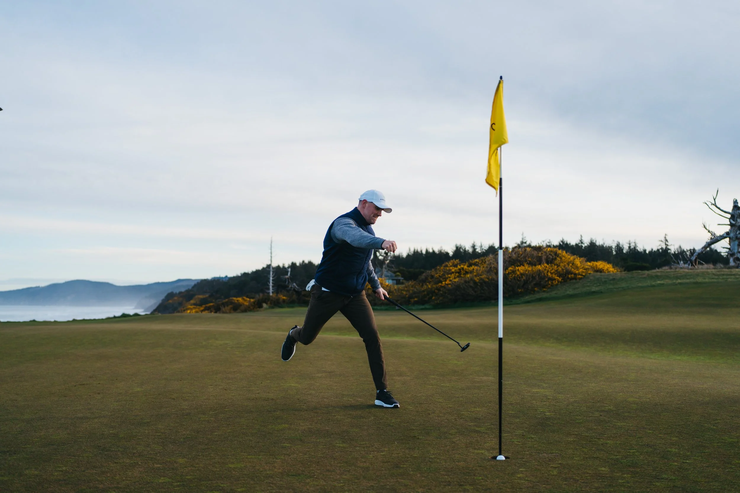 A man playing golf near a flag on a golf course.