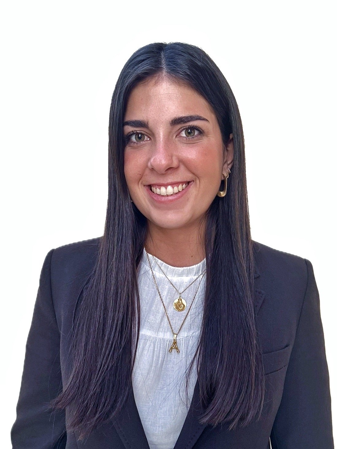 Black and white aerial photo of six people rowing a long, narrow boat in open water.