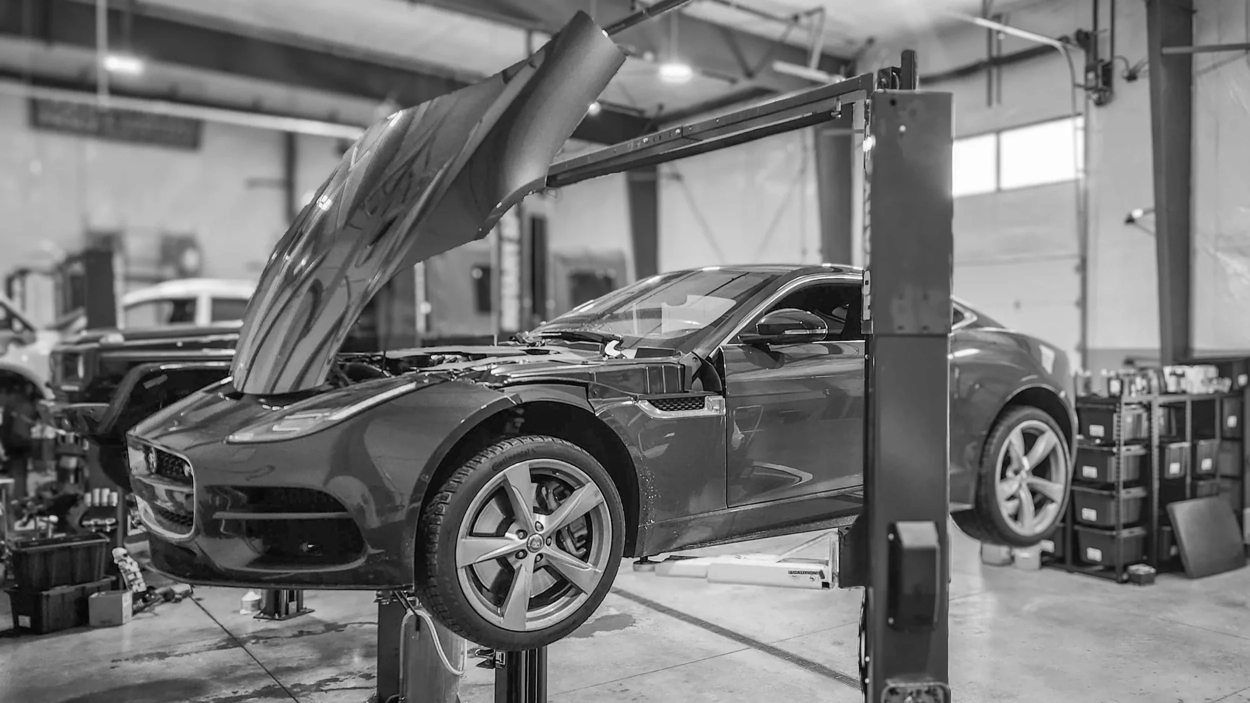 A jaguar sports car is on the lift for service
