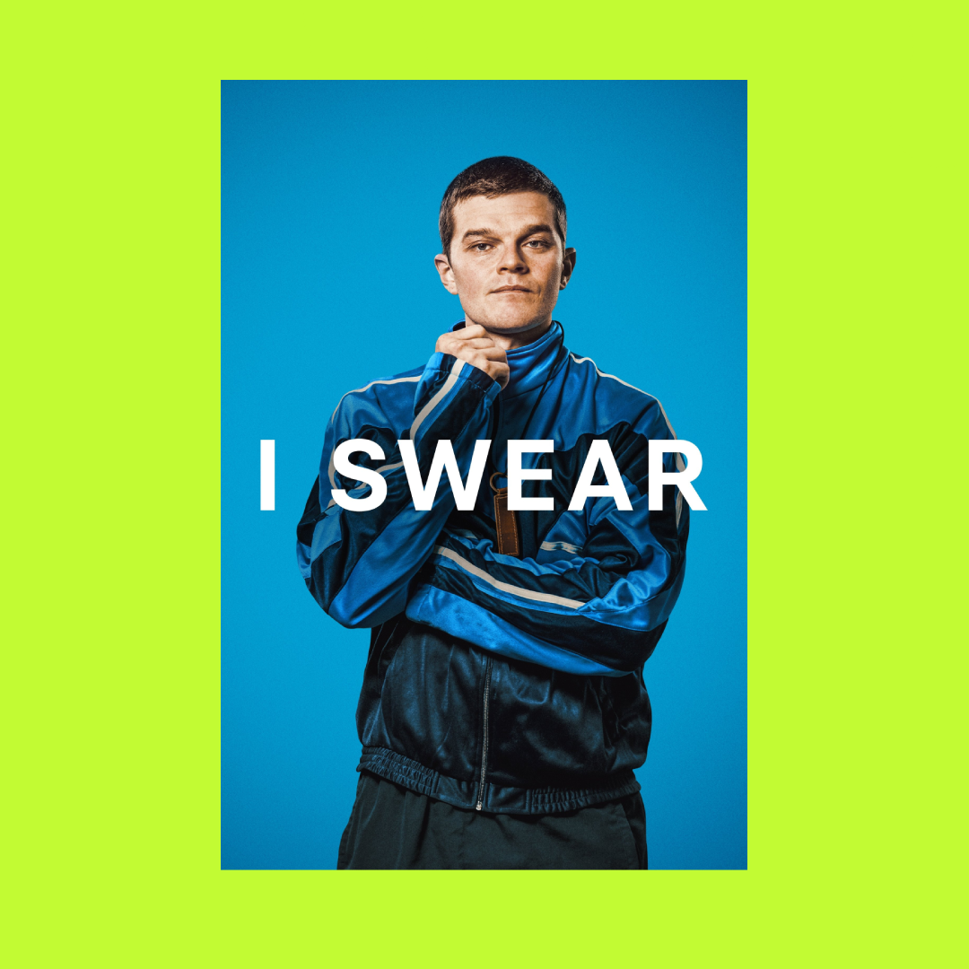 A man wearing a blue sports jacket stands against a blue background, with the words 'I SWEAR' written across the front.