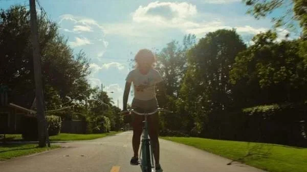A person riding a bicycle in the film Waves