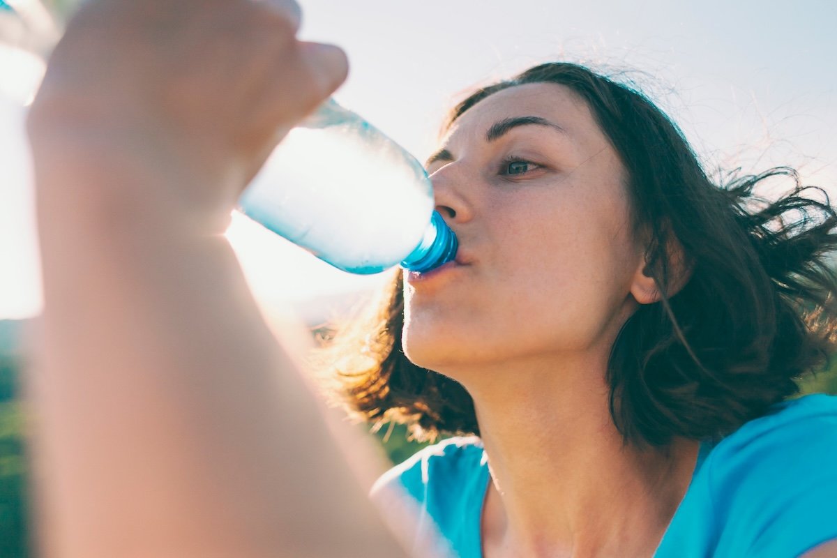 A woman drinking a bottle of water.