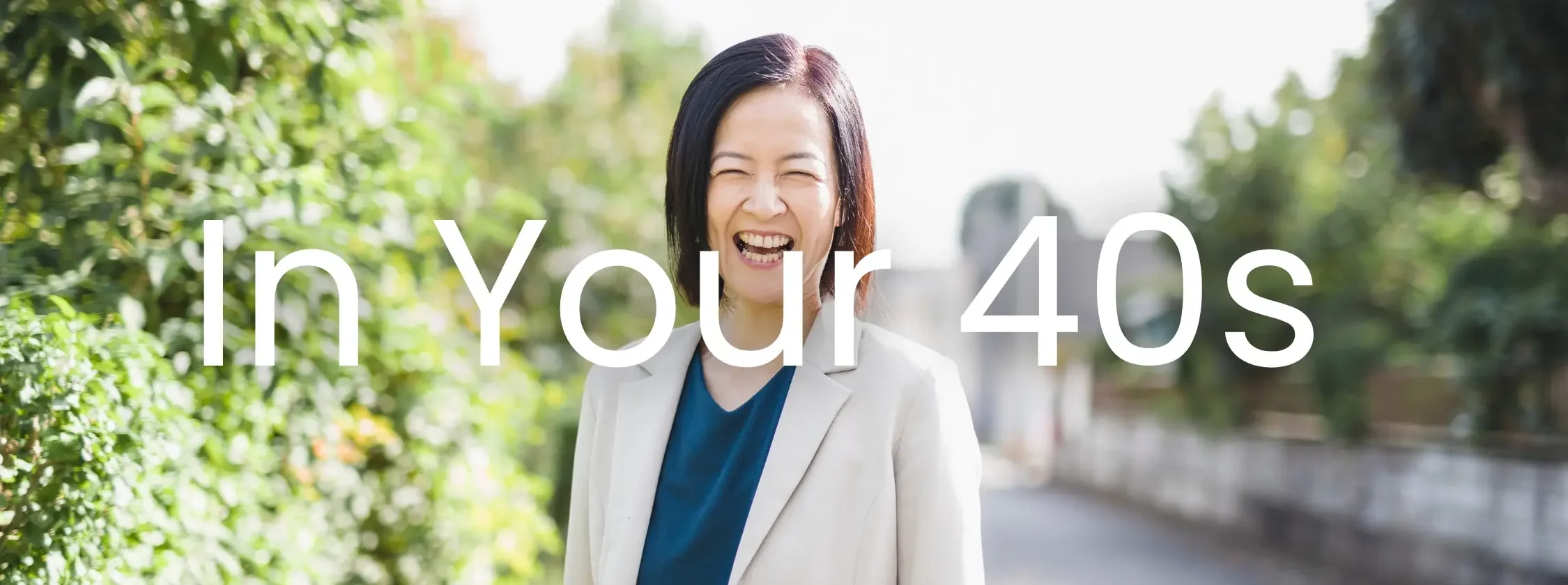 Smiling Asian woman in her 40s outdoors representing women's health screenings including mammograms and perimenopause care