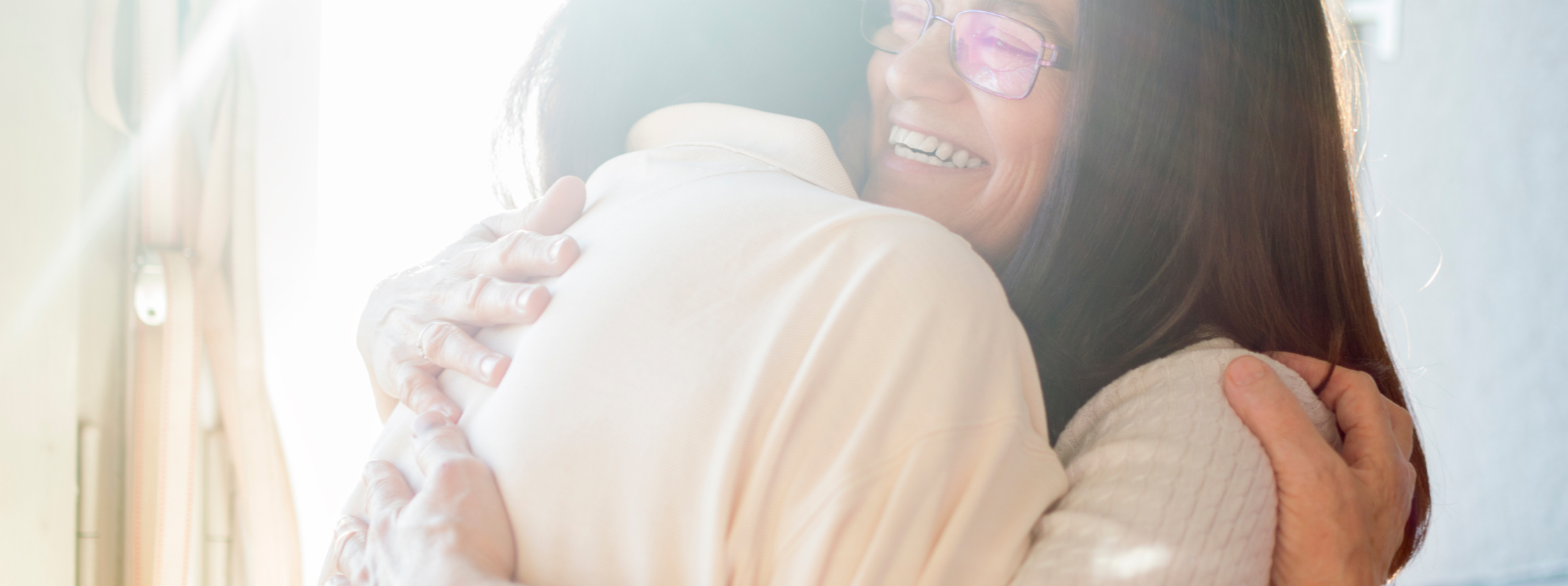 two women smiling and embracing