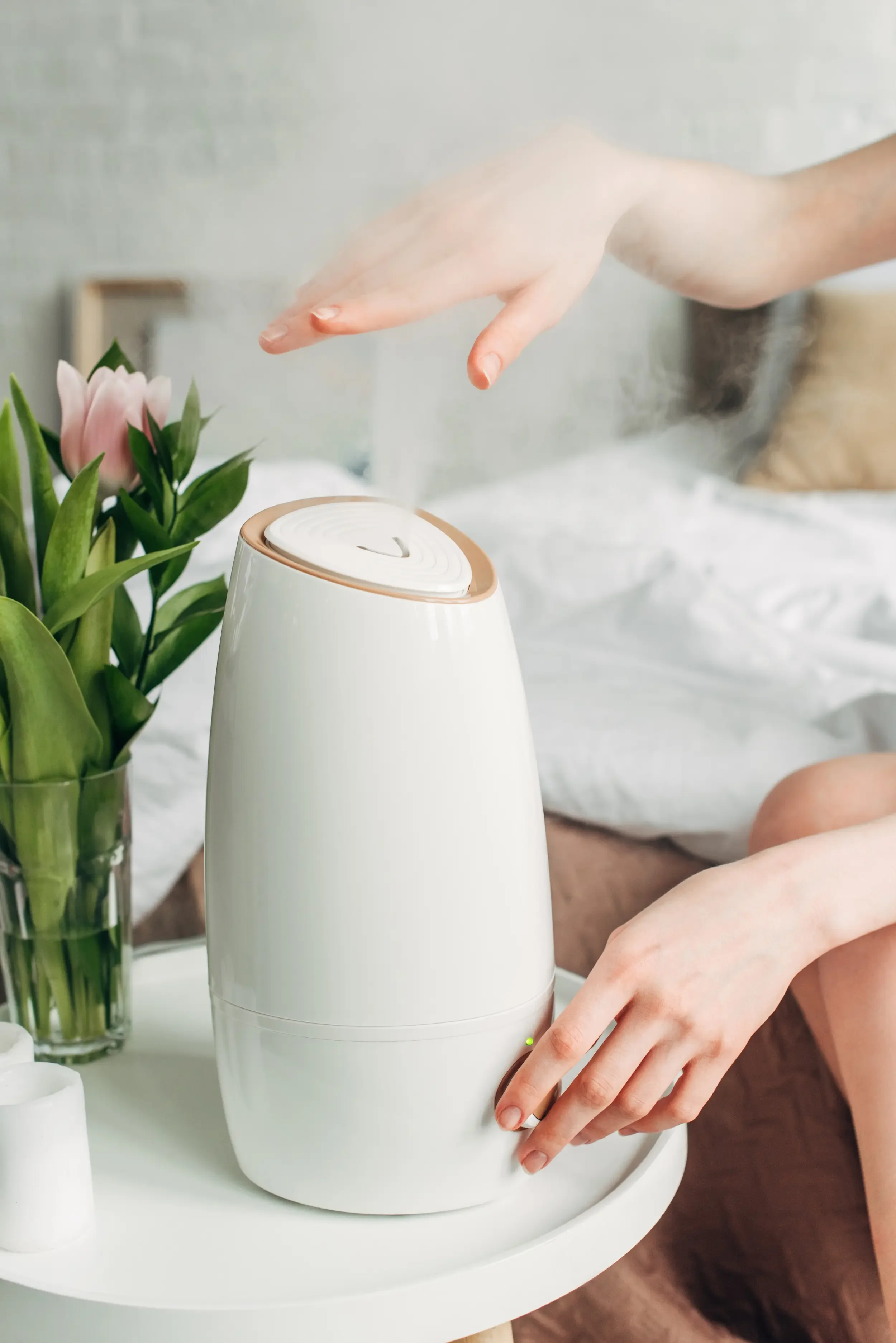 A woman's hands adjusting a bedside humidifier.