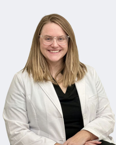 Amanda Dunn, APRN, AGNP-C, Ms.Medicine nurse practitioner in Frisco, TX, smiling in a white coat and glasses