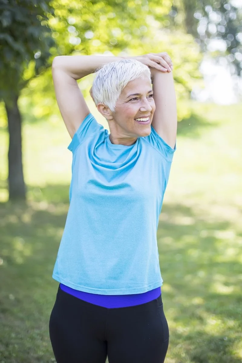A woman stretching outside.