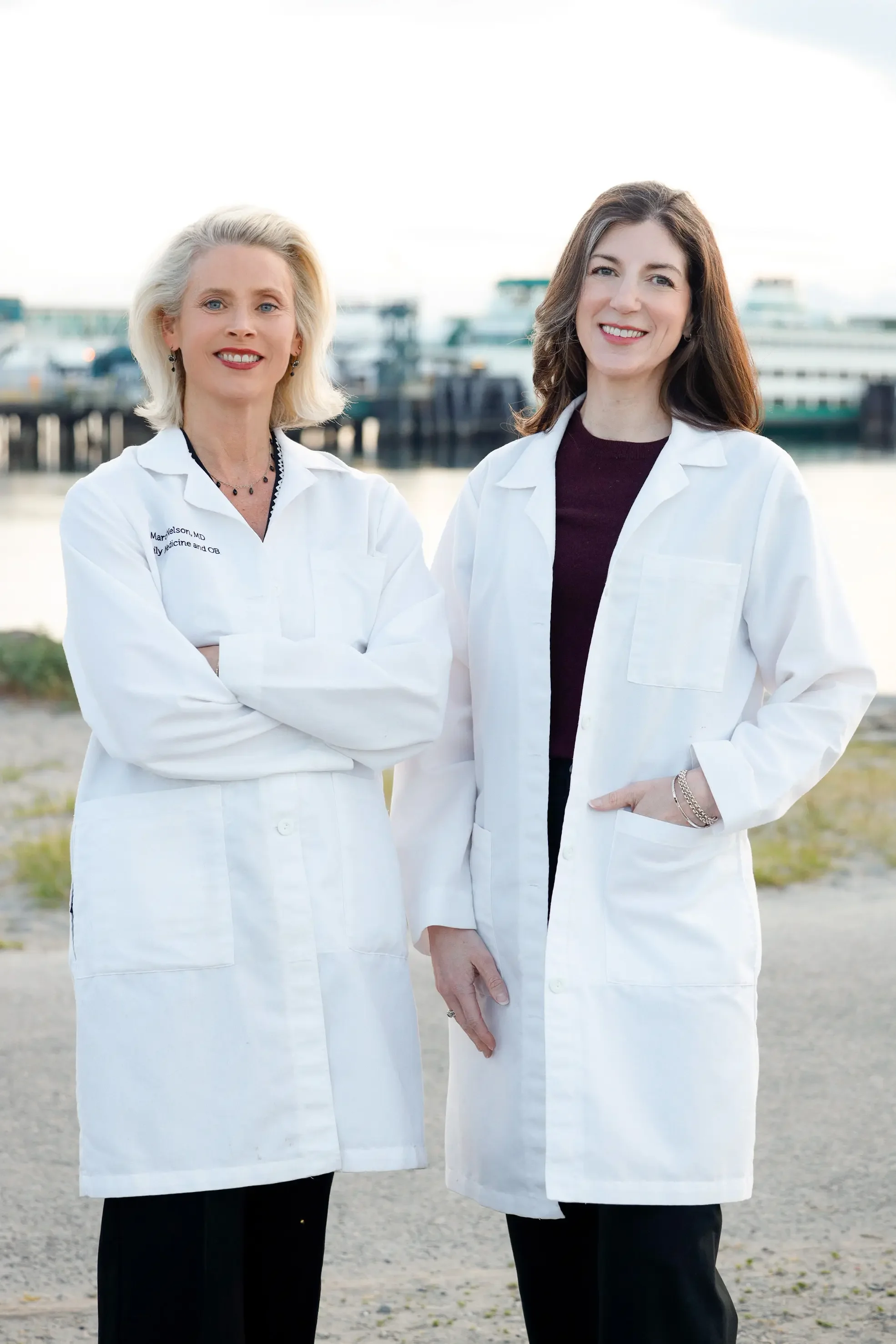 Dr. Marci Nelson and Dr. Jill Casey, concierge family medicine physicians and co-founders of Trillium Concierge Medicine in Shoreline, WA, standing together outdoors near the Puget Sound waterfront