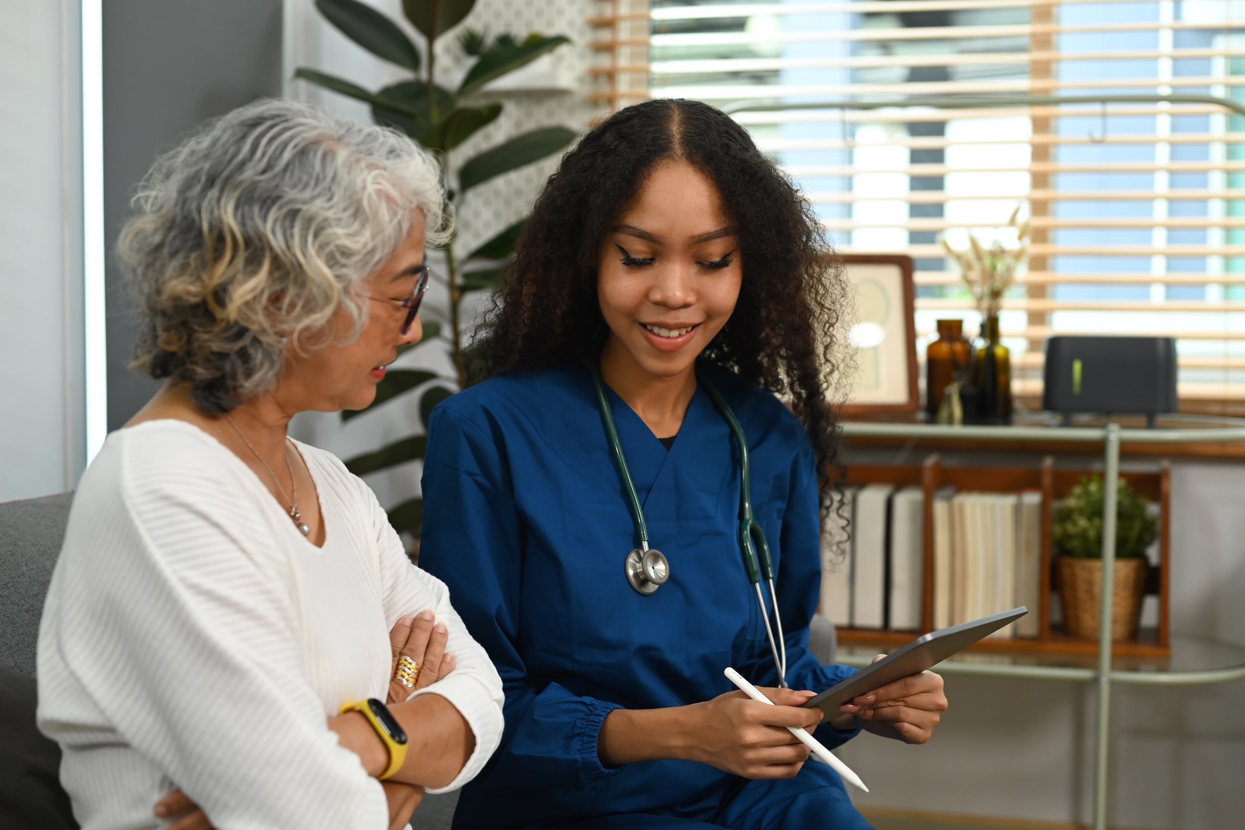A woman and her doctor looking at a tablet.