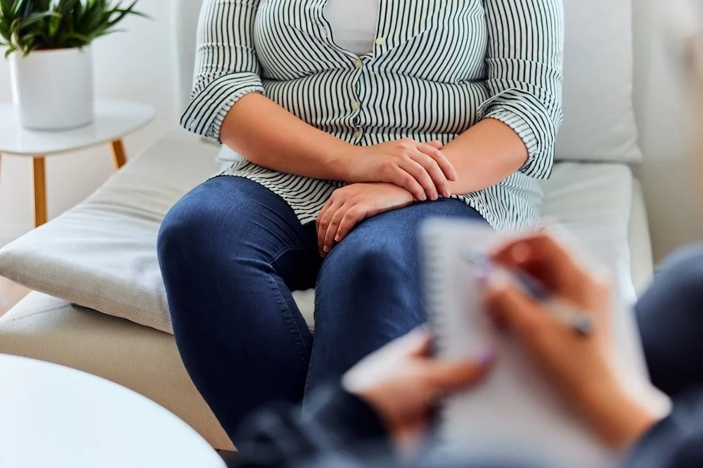 An overweight woman talking to a therapist.