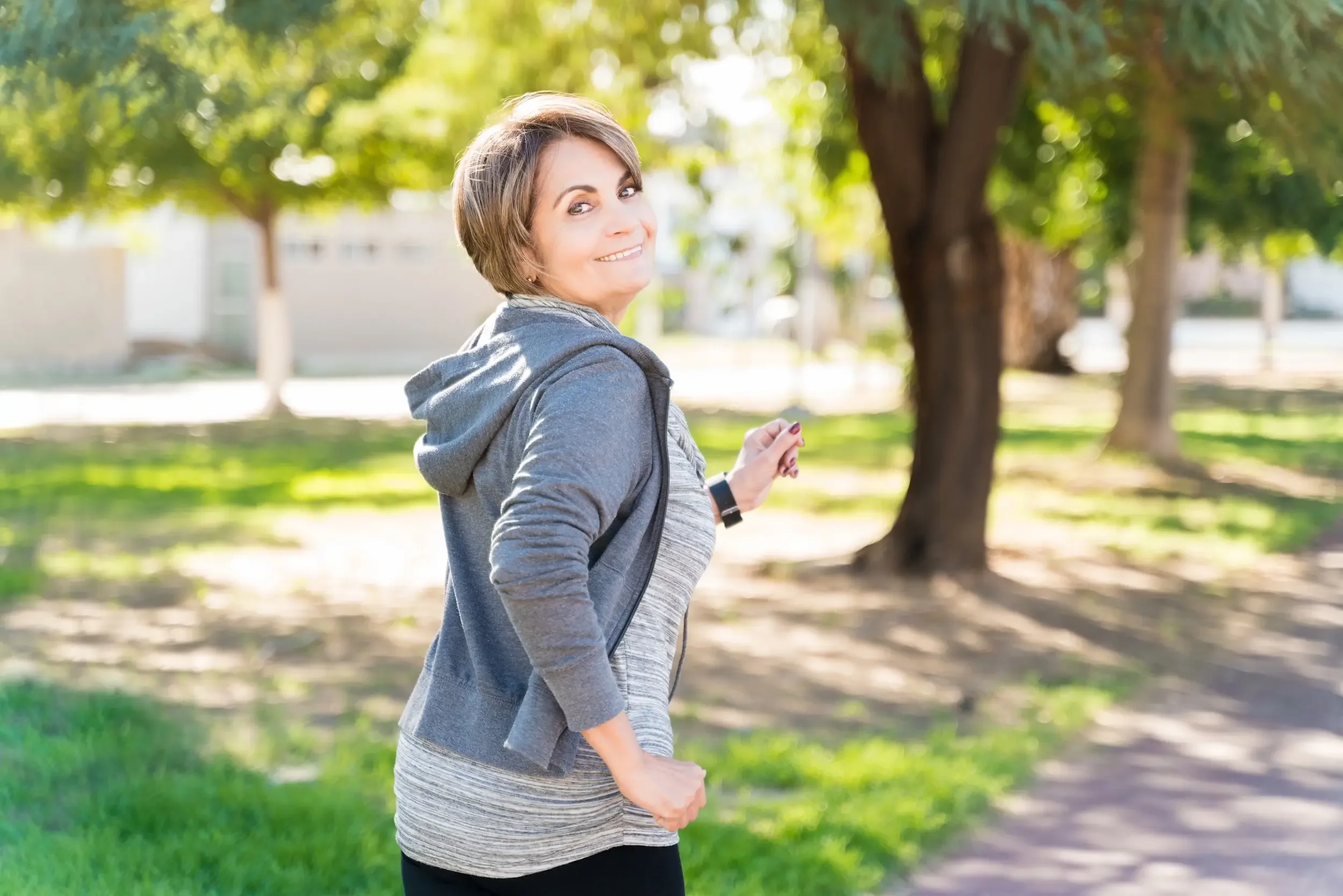 An older woman exercising outdoors.