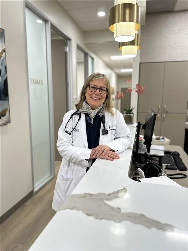 Dr. Anna Manatis, concierge internal medicine physician, at the front desk of her Cape Cod practice