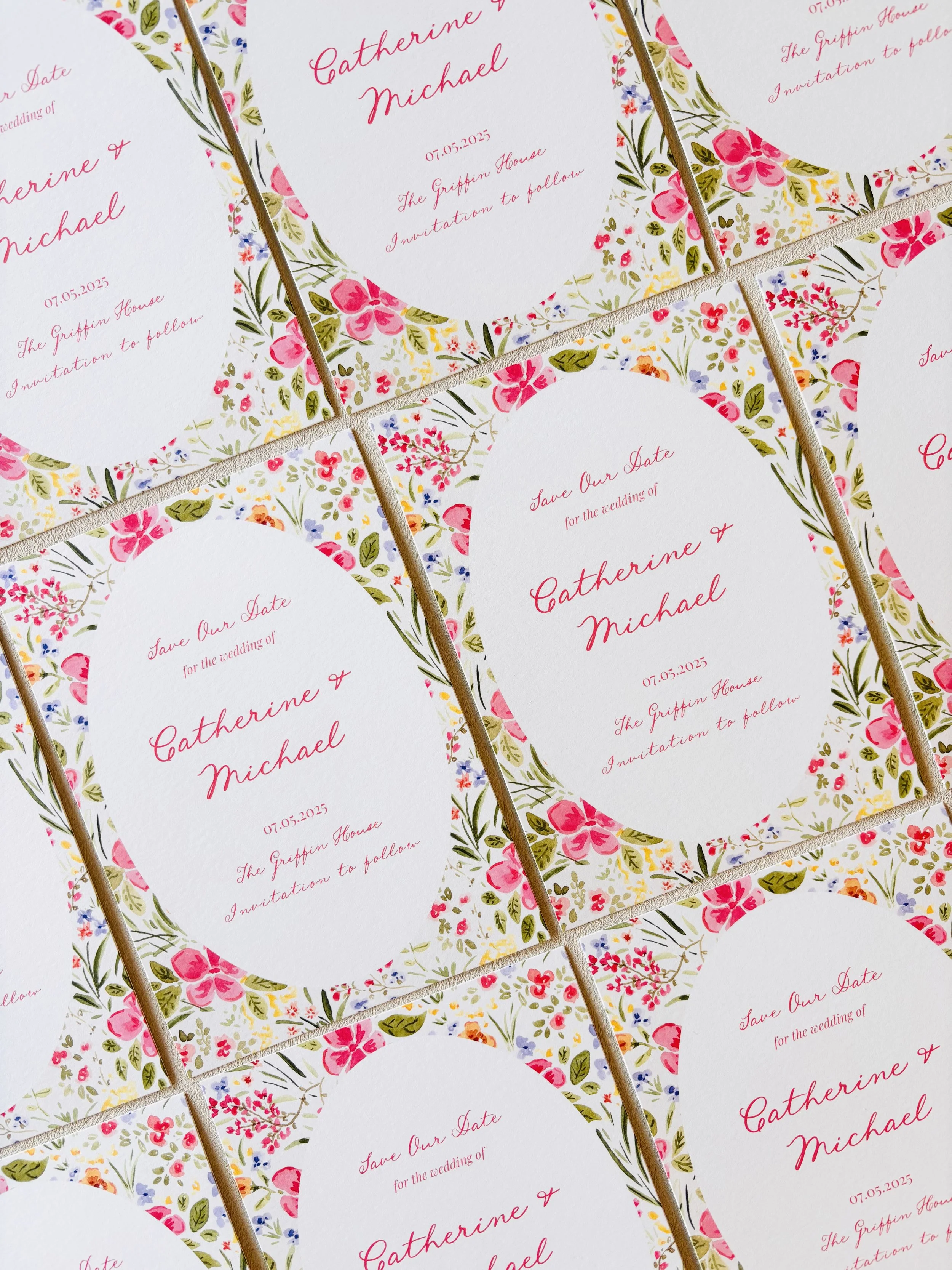 Multiple floral wedding invitations with pink and green accents and elegant script for the names and details.
