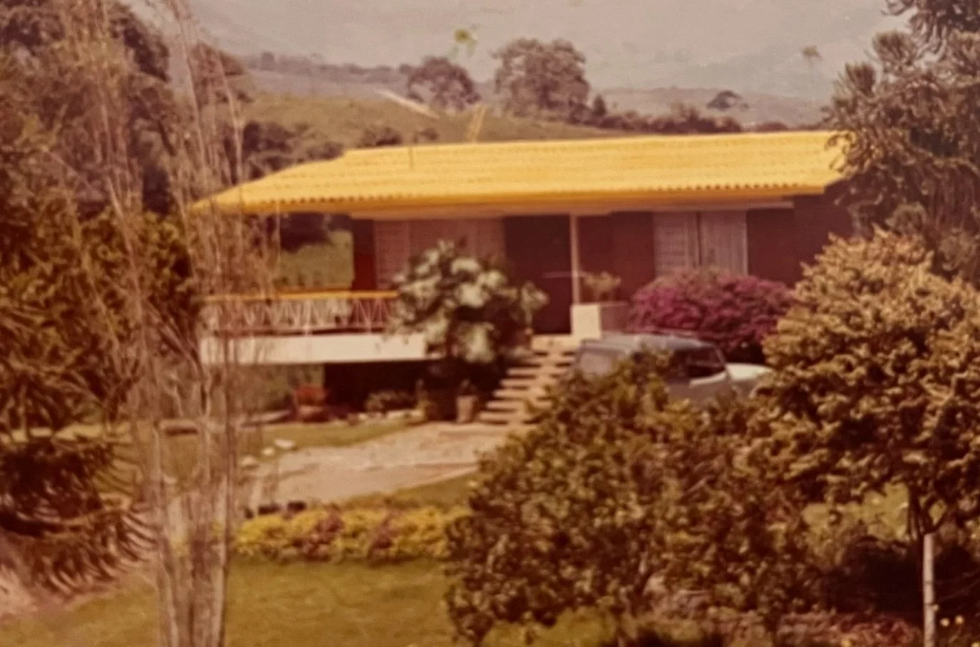 Fotografía histórica de la casa de La Araucana, con techo amarillo y jardín.