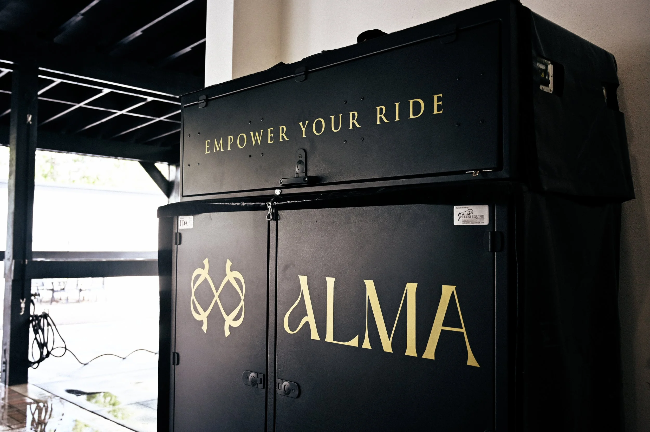 Black locker with yellow text saying 'Empower Your Ride' and 'ALMA' logo.