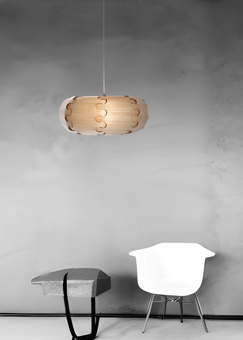 Modern interior with a minimalist design featuring a white chair, a small grey table, a bamboo veneer Urchin pendant lamp shade, and a large wall with a doorway.