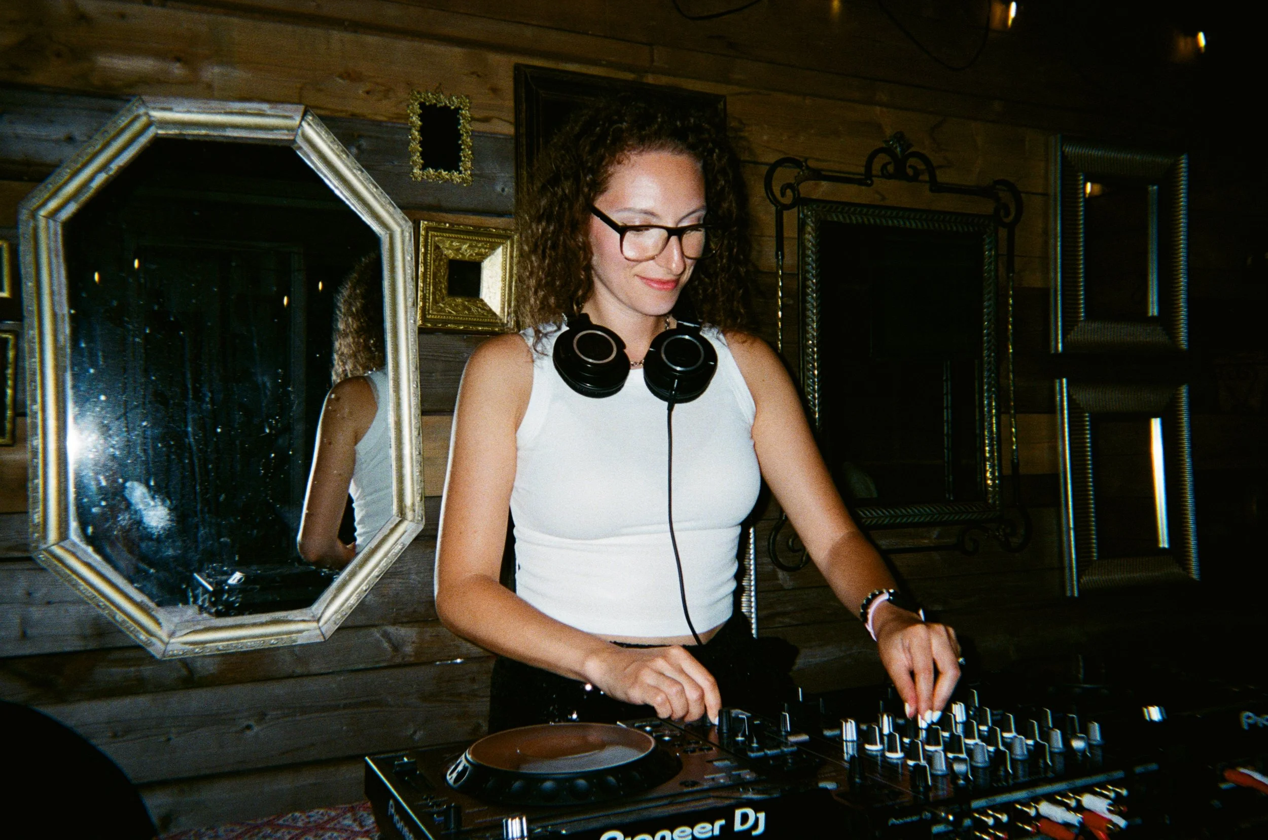 Female DJ using a professional DJ setup and smiling