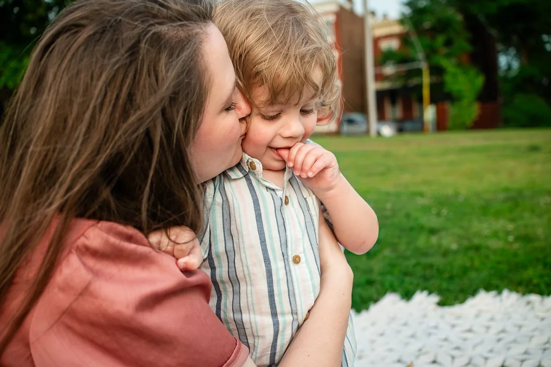 Mother kissing toddler son during a spring, sunset family session in Libby Hill Park in Richmond, VA by Erin E Gallagher Photography