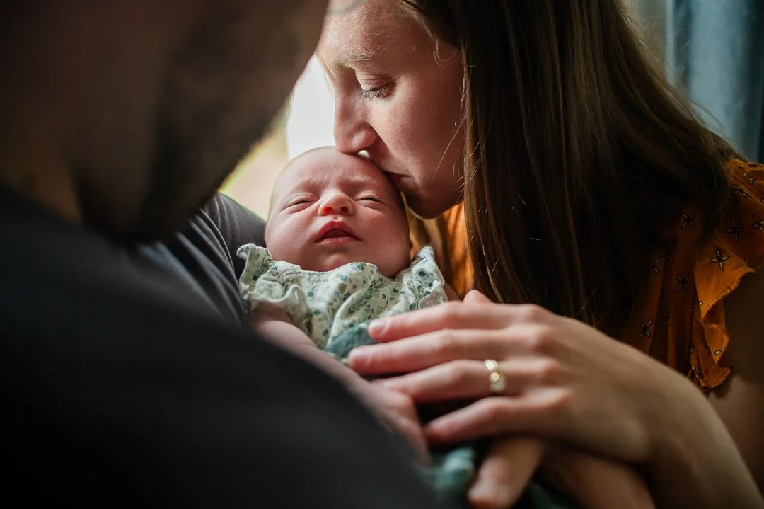mother kissing baby girl during inhome newborn photos in Staunton, VA by Erin E Gallagher Photography