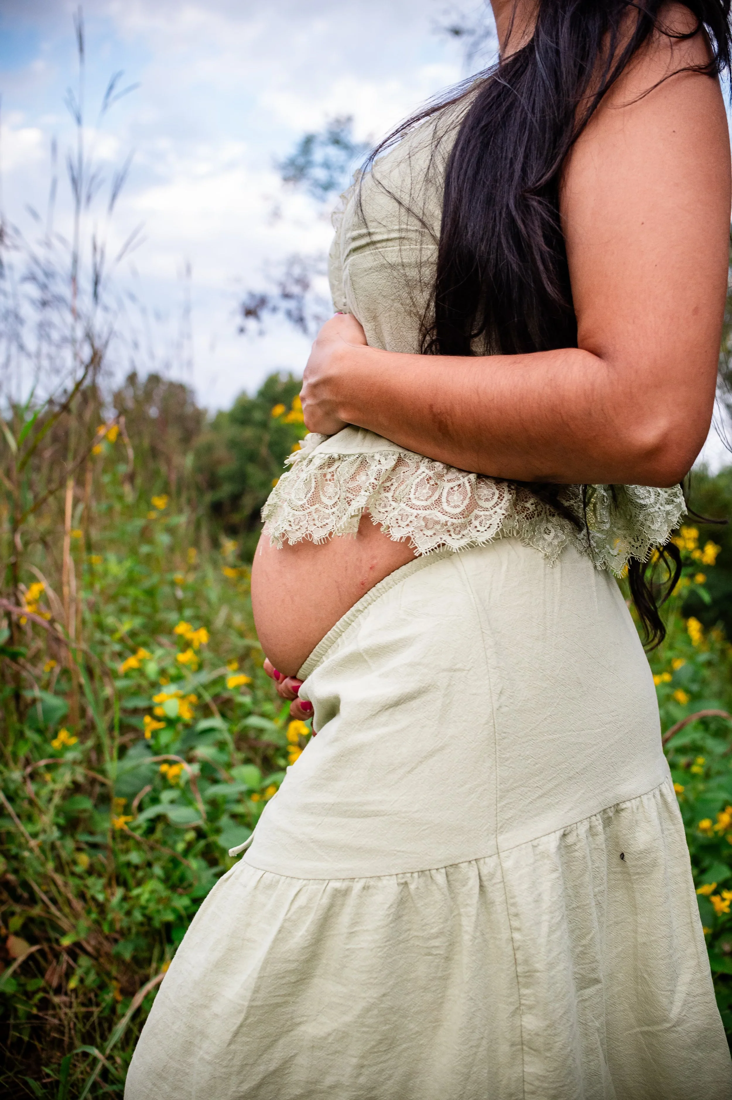 new mom poses while holding pregnant belly during a summer maternity session in Charlottesville, VA by Erin E Gallagher Photography