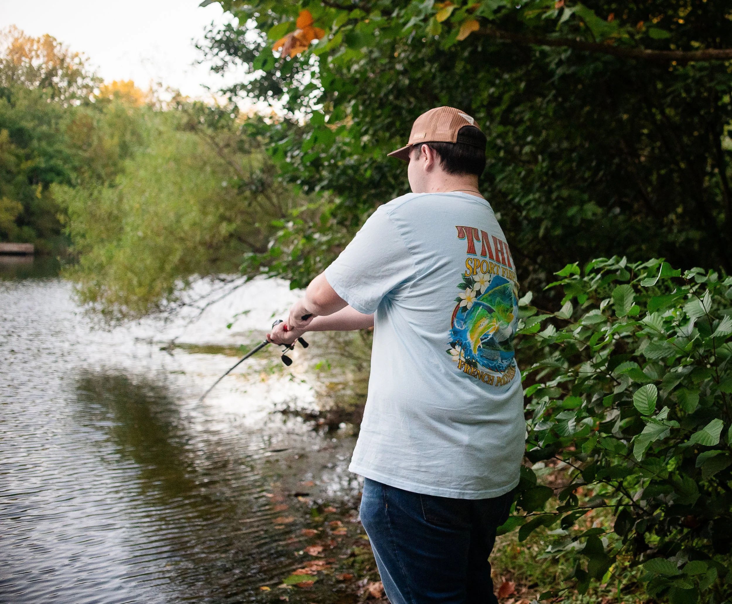 Young man fishing during a summer senior session at sunset-on the Monticello trail in Charlottesville, VA by Erin E Gallagher Photography