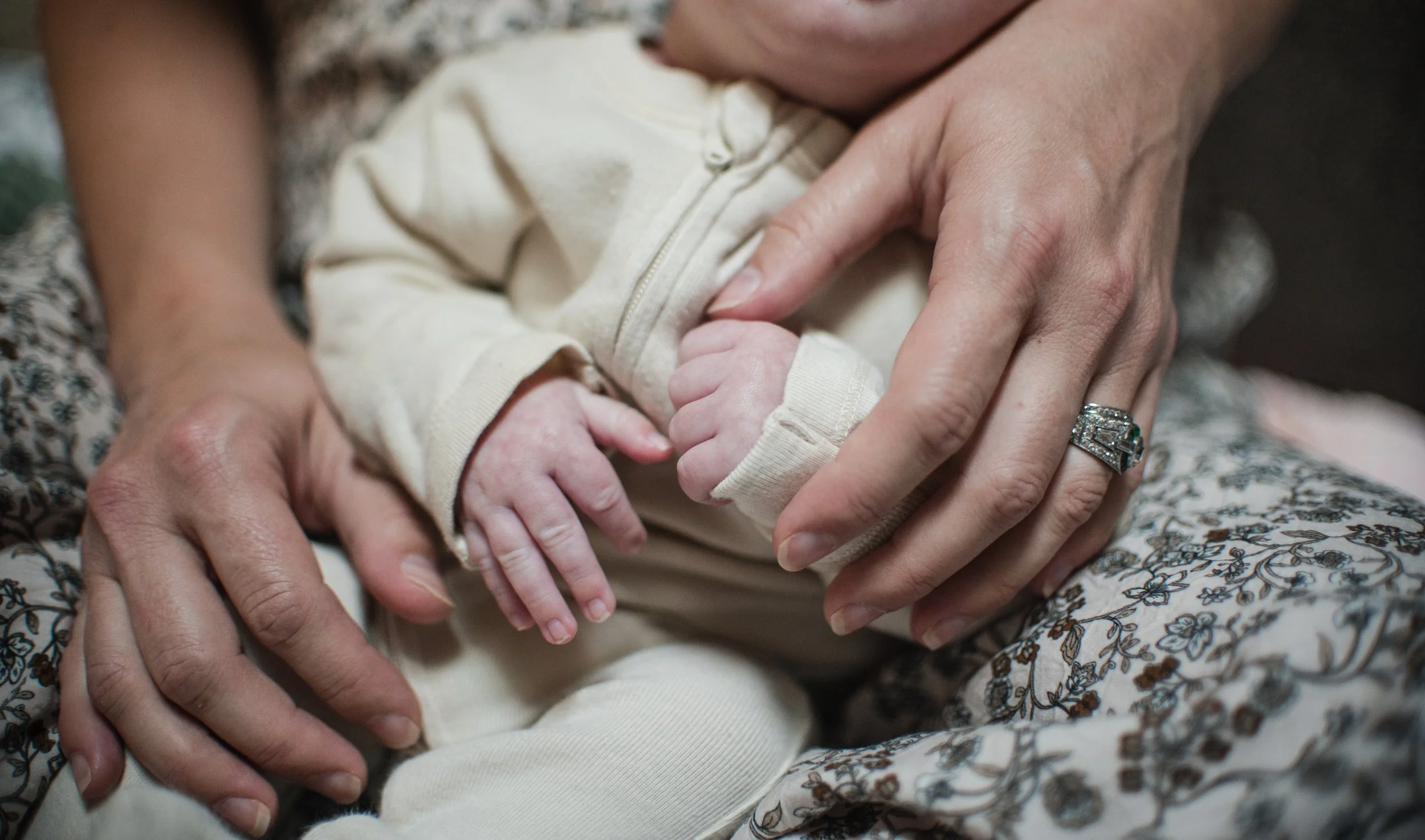 close up picture of a mom holding newborn son's hands during an in-home newborn session in Charlottesville, VA by Erin E Gallagher Photography