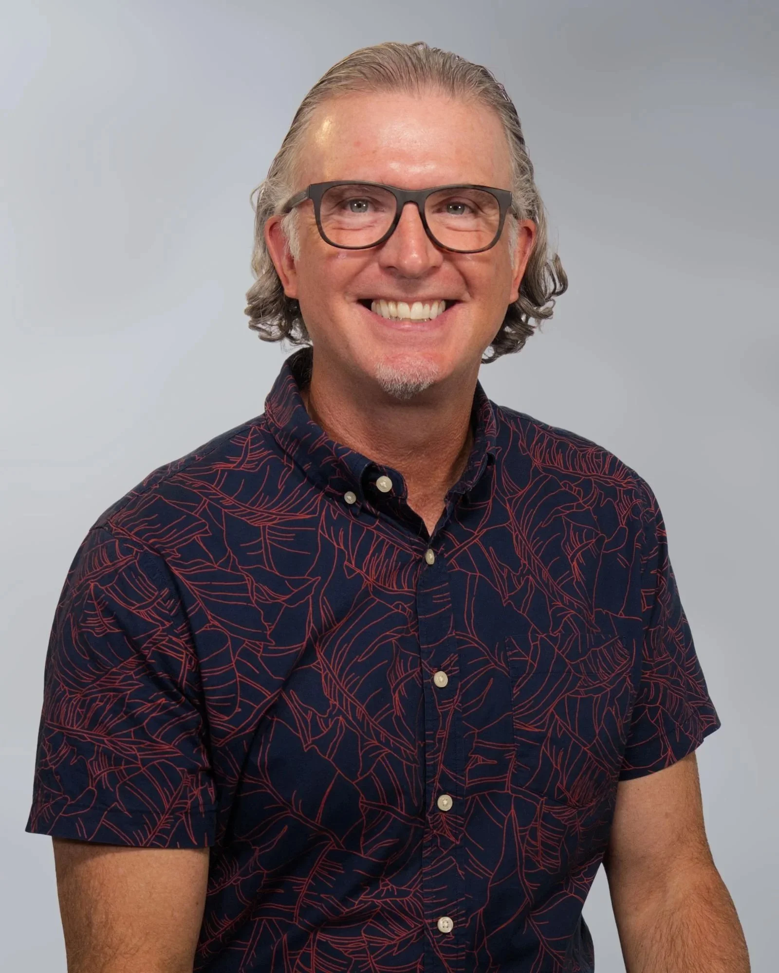 Smiling person wearing glasses and a Puma shirt.