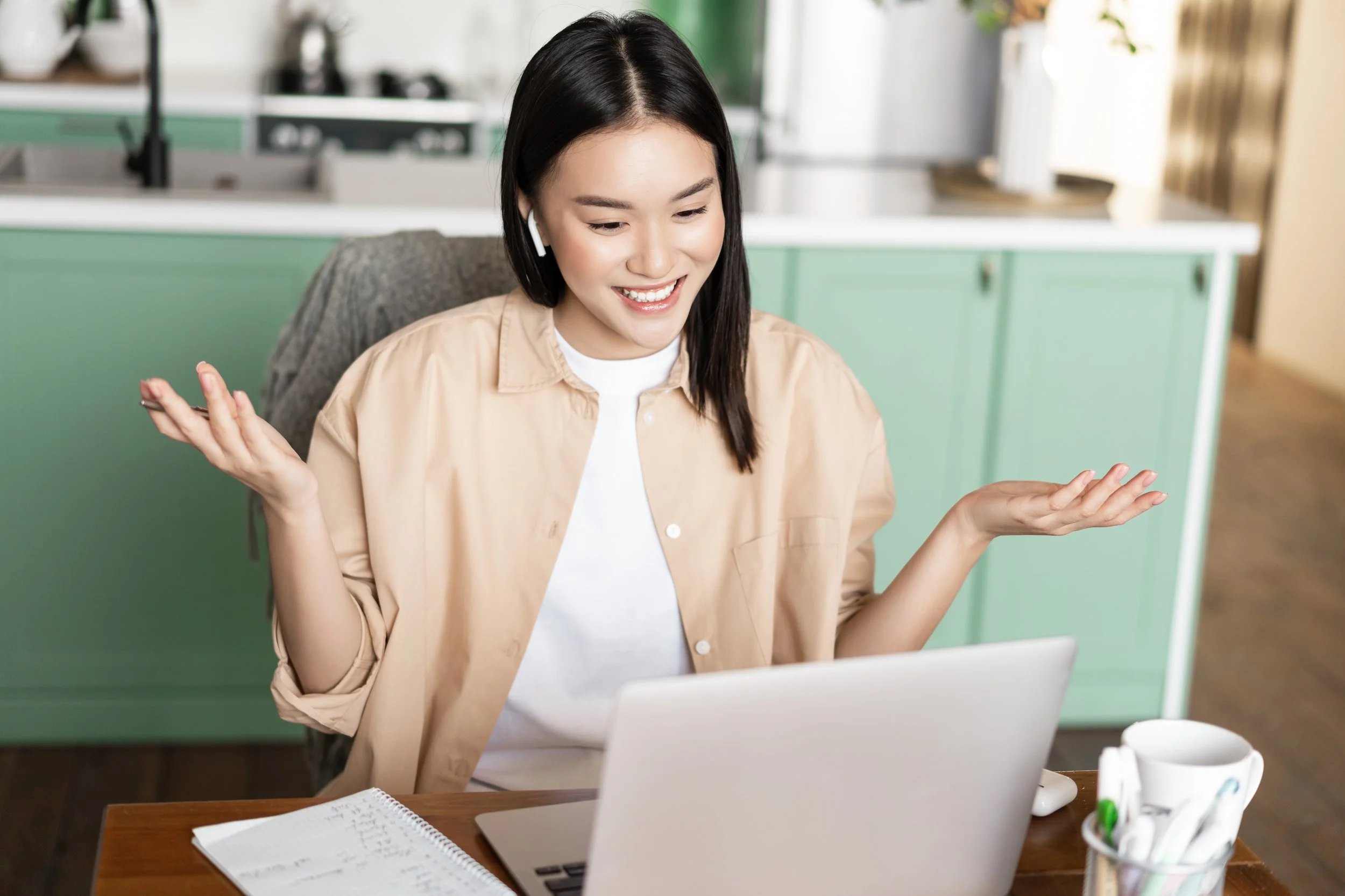 Woman in beige shirt smiles with arms raised at laptop, proof you don’t need it all figured out - The Private Practice Pro