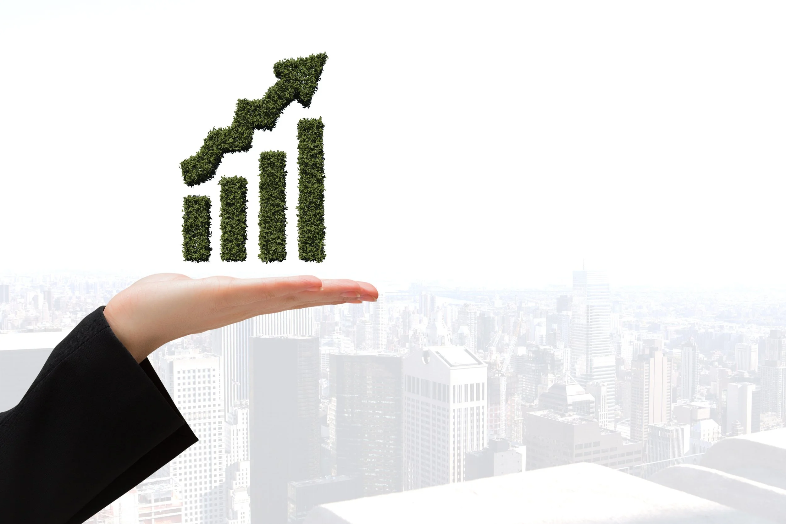 A hand holds a graph depicting growth, with a city skyline in the background, symbolizing community development.