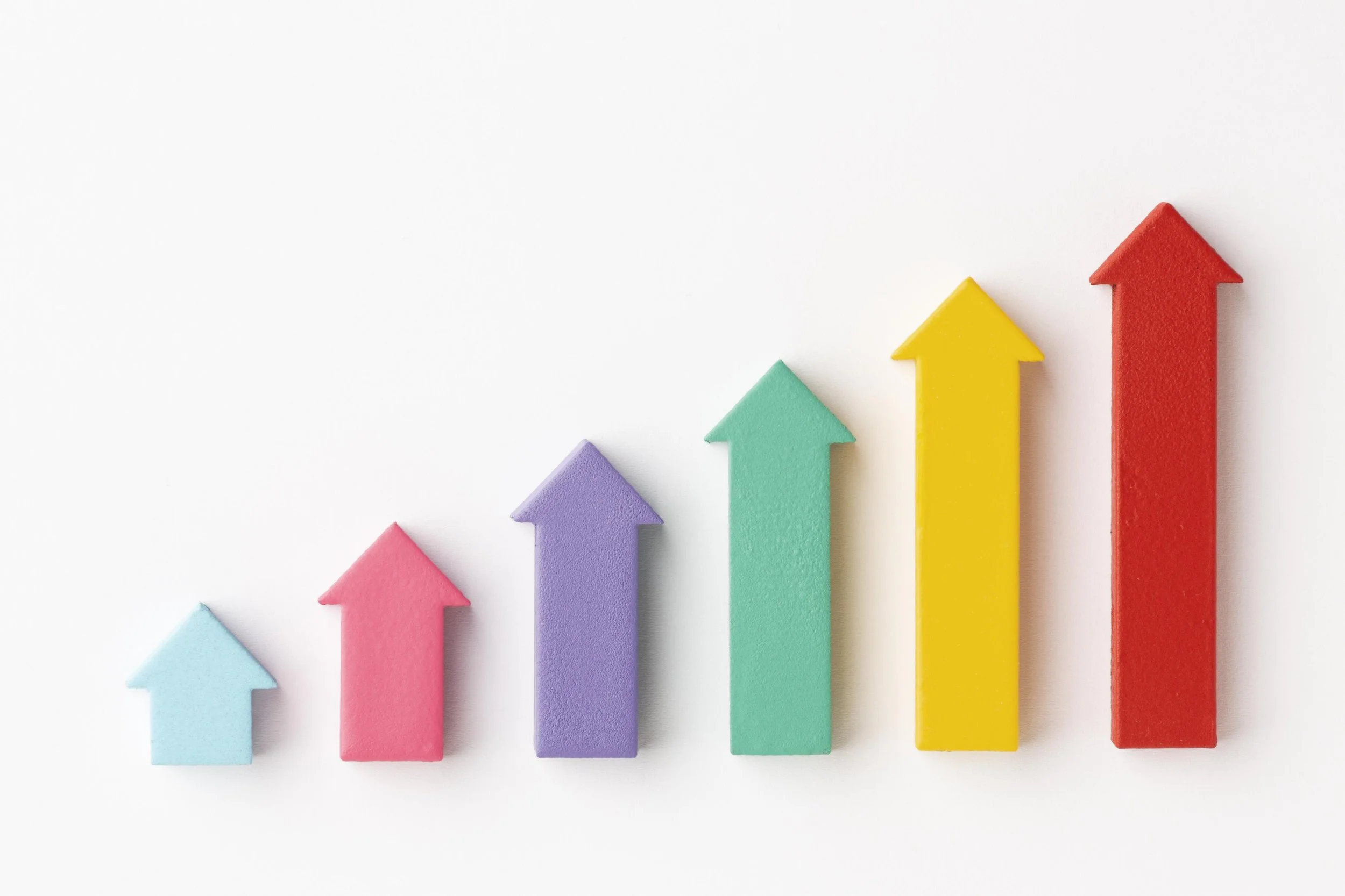 Colorful wooden arrows arranged on a white background, symbolizing growth - The Private Practice Pro