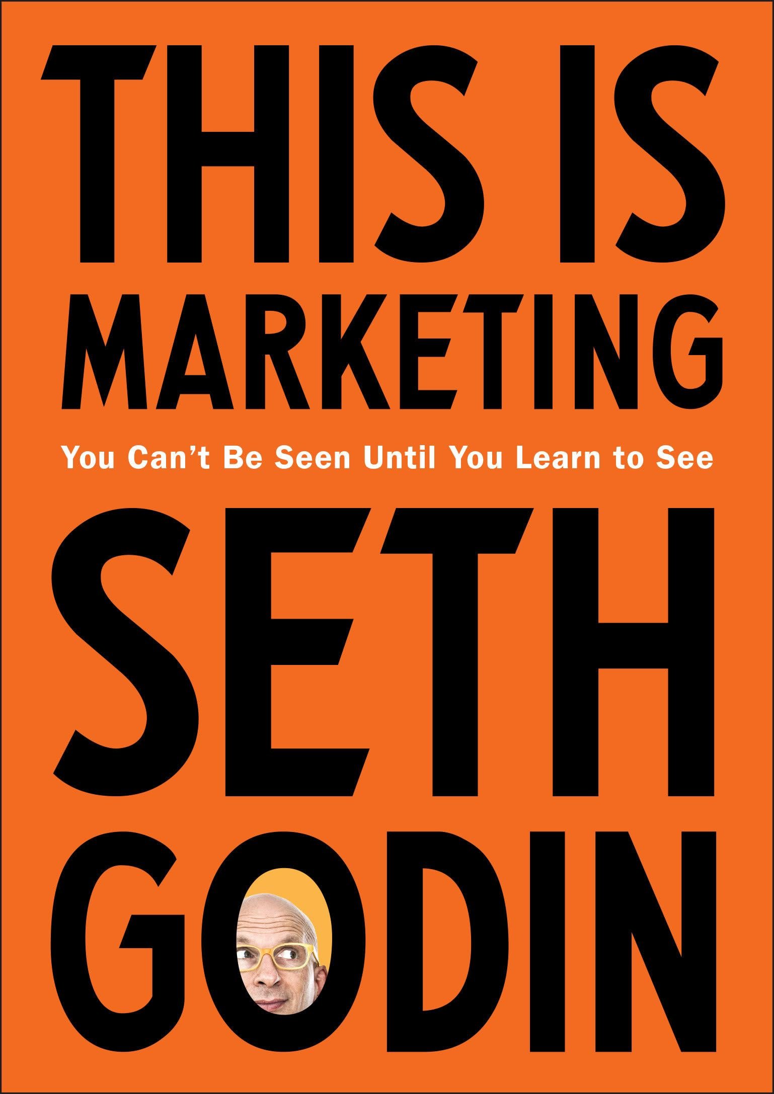 Bold orange background with large black text that says 'THIS IS MARKETING' and 'SELLING' and smaller white text that reads 'You Can't Be Seen Until You Learn to See'. There are two photos of a man with glasses and a bald head, one at the bottom and one partially visible at the top.