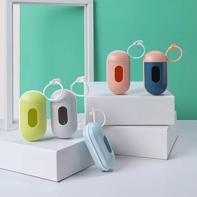 Colorful portable device cases with attached key rings, displayed on white platforms against a turquoise background.