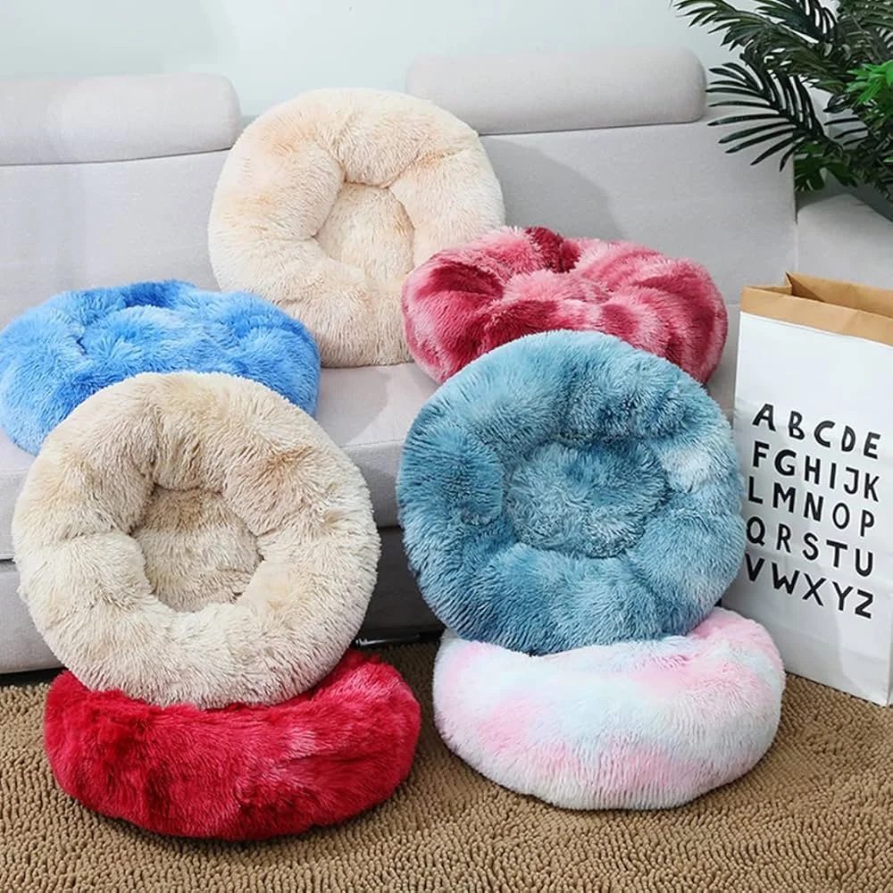 Plush, round, fluffy cushions in various pastel colors including cream, blue, pink, and red on a beige carpet and a white sofa, with a shopping bag with alphabet letters and a plant in the background.