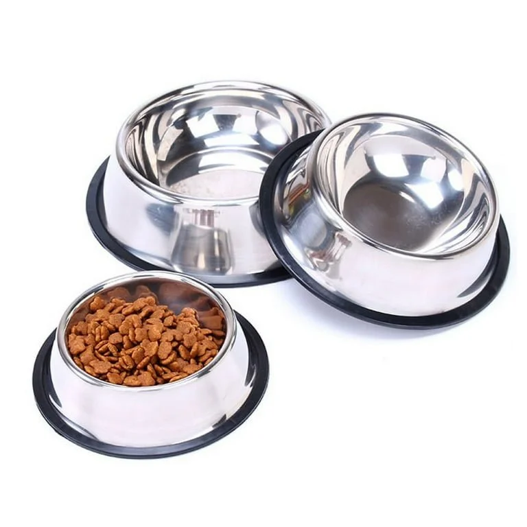 Two empty stainless steel pet bowls with black rubber bases and one filled with dry pet food.