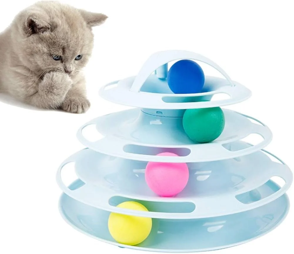 A beige cat watching a multi-level ball maze toy with colorful balls on a white background.