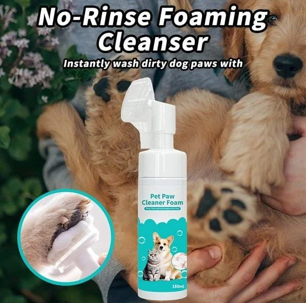 A bottle of pet paw cleaner foam in front of two puppies being held by a person. The label shows a cat and dog, and the text indicates it is a no-rinse foaming cleanser for cleaning dirty dog paws.