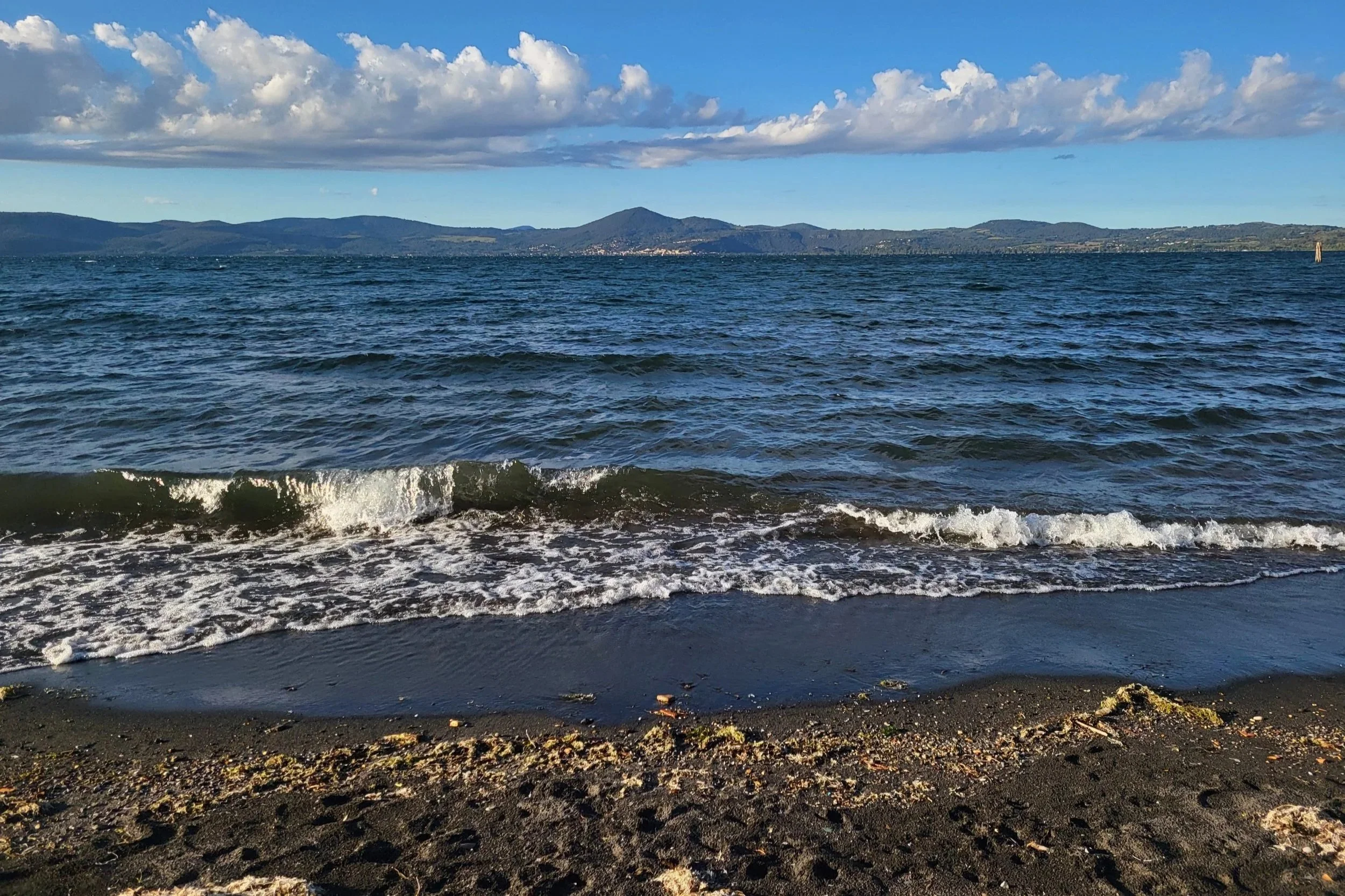 Black volcanic sand beach on Lake Bracciano near Anguillara Sabazia