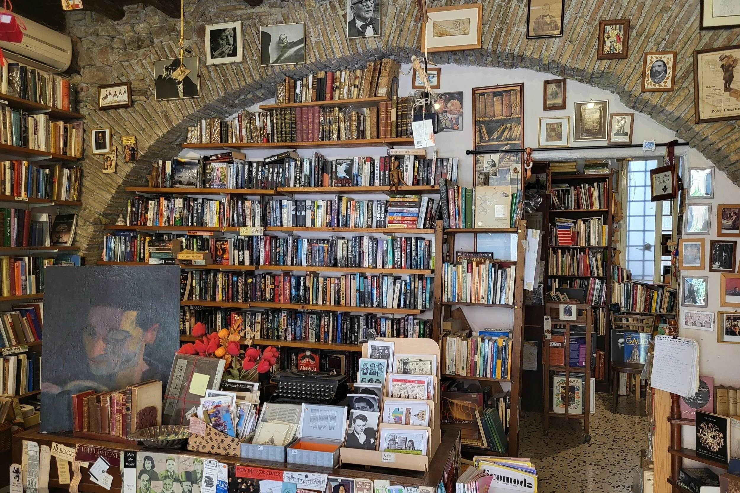 Inside view of The Open Door Bookshop in Rome with rows of second hand books.