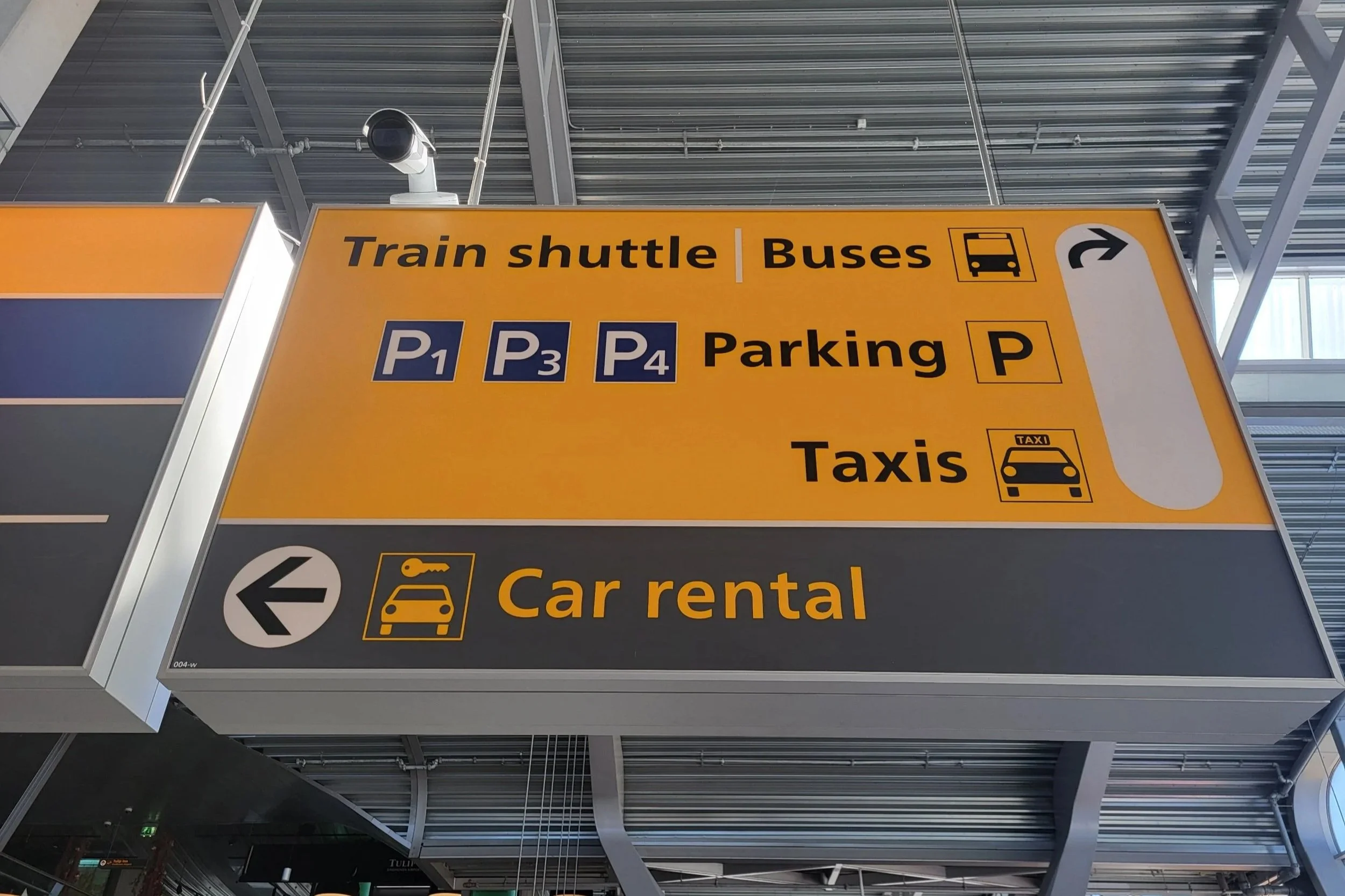 Yellow sign indicating where the bus stop is at Eindhoven Airport