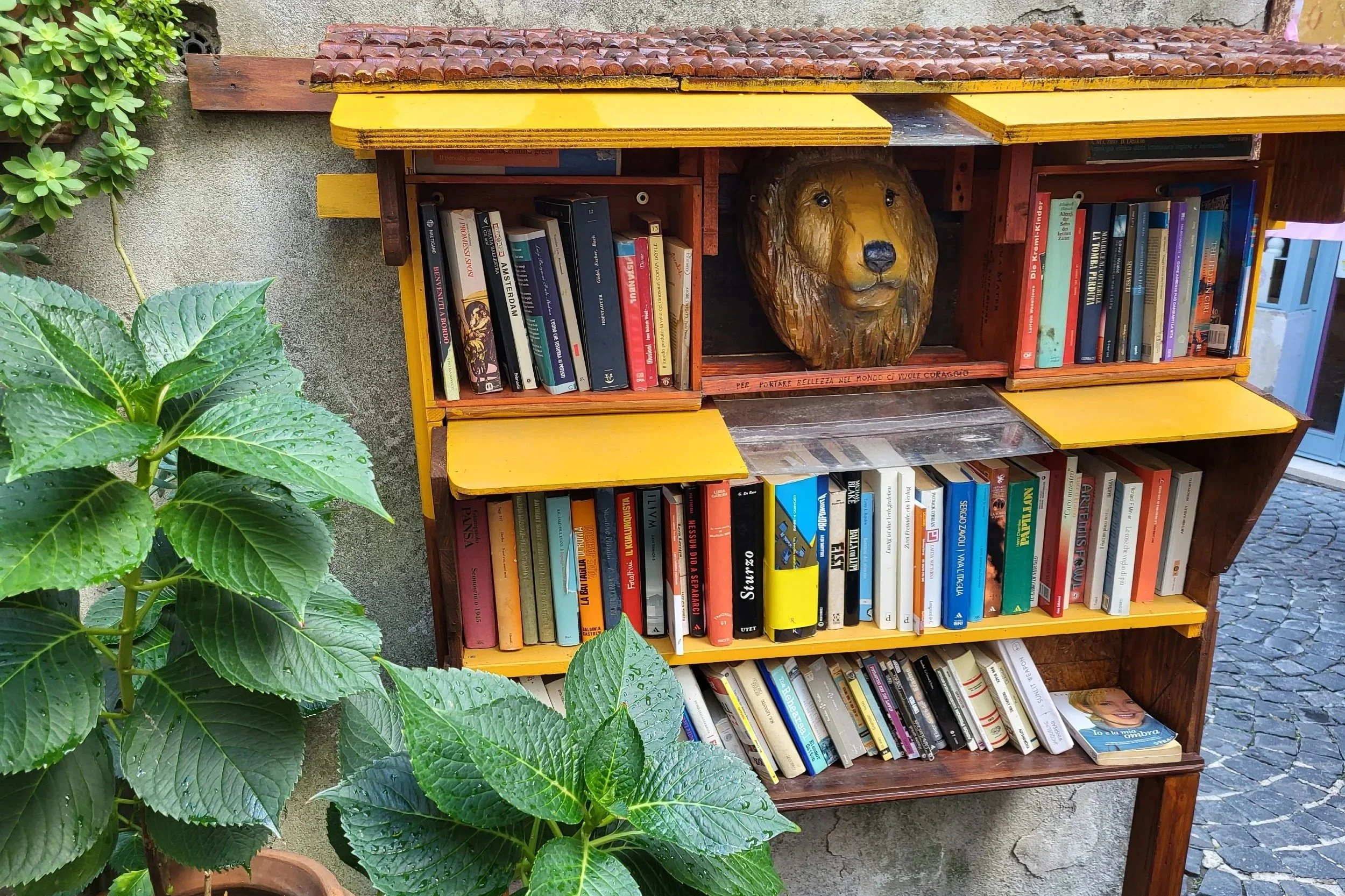 Charming little street library tucked between stone houses in the historic center of Anguillara Sabazia