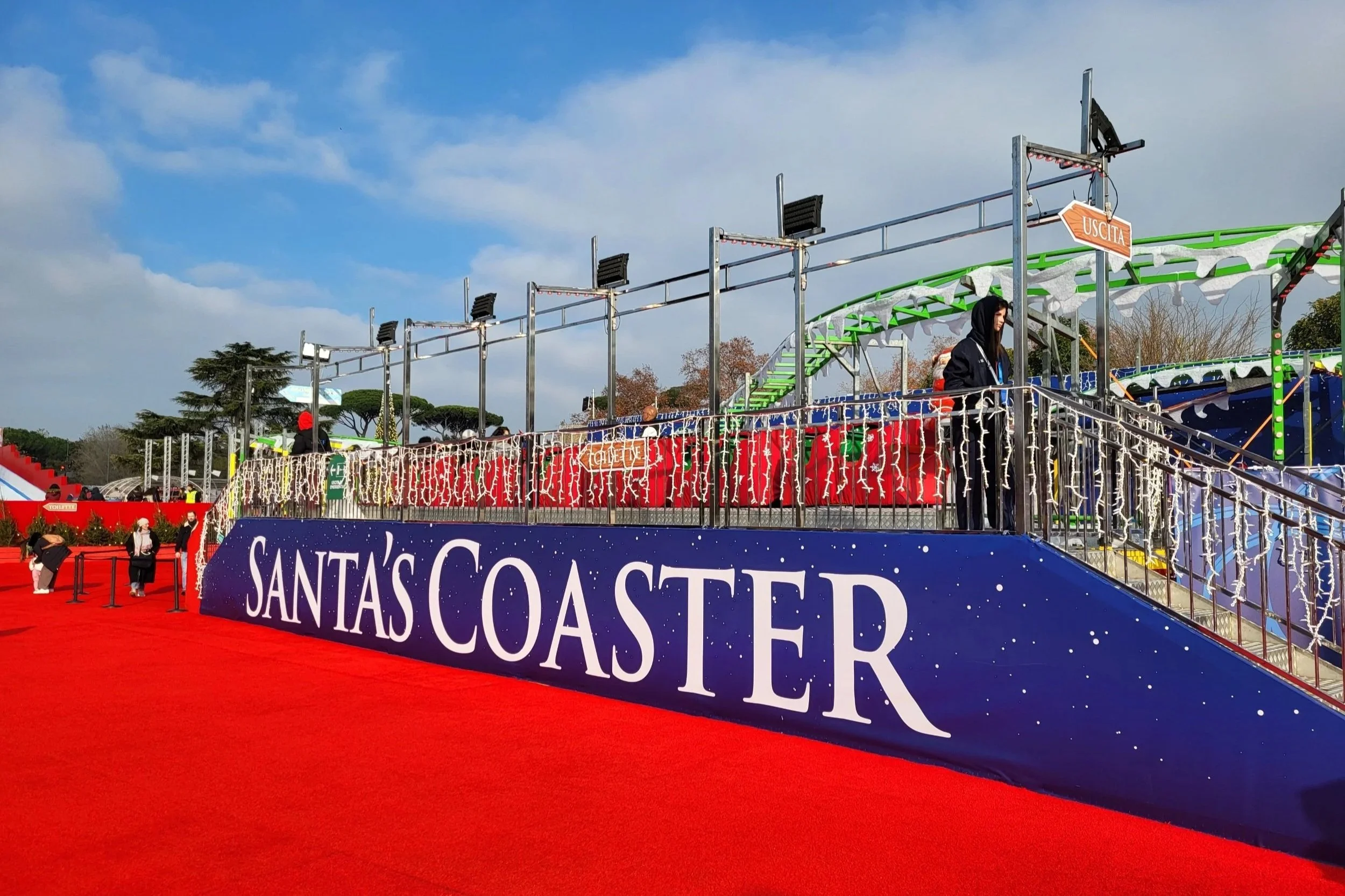 Small coaster ride decorated with festive Christmas lights at Christmas World Rome