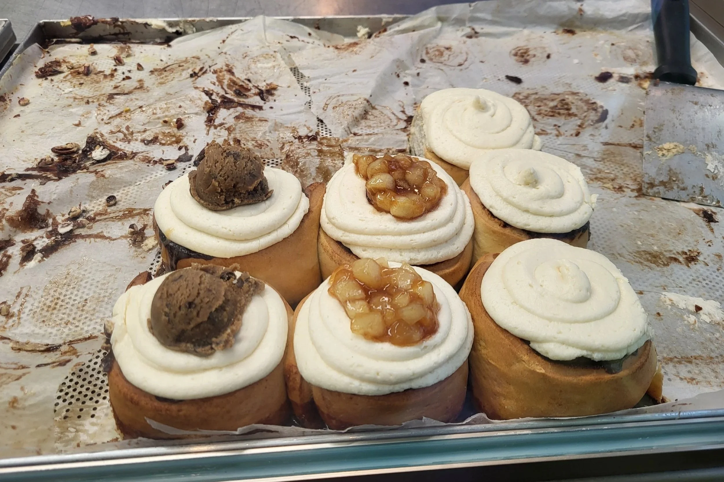 Picture of vegan cinnamon rolls in different flavours. Cookie dough, apple and classic.