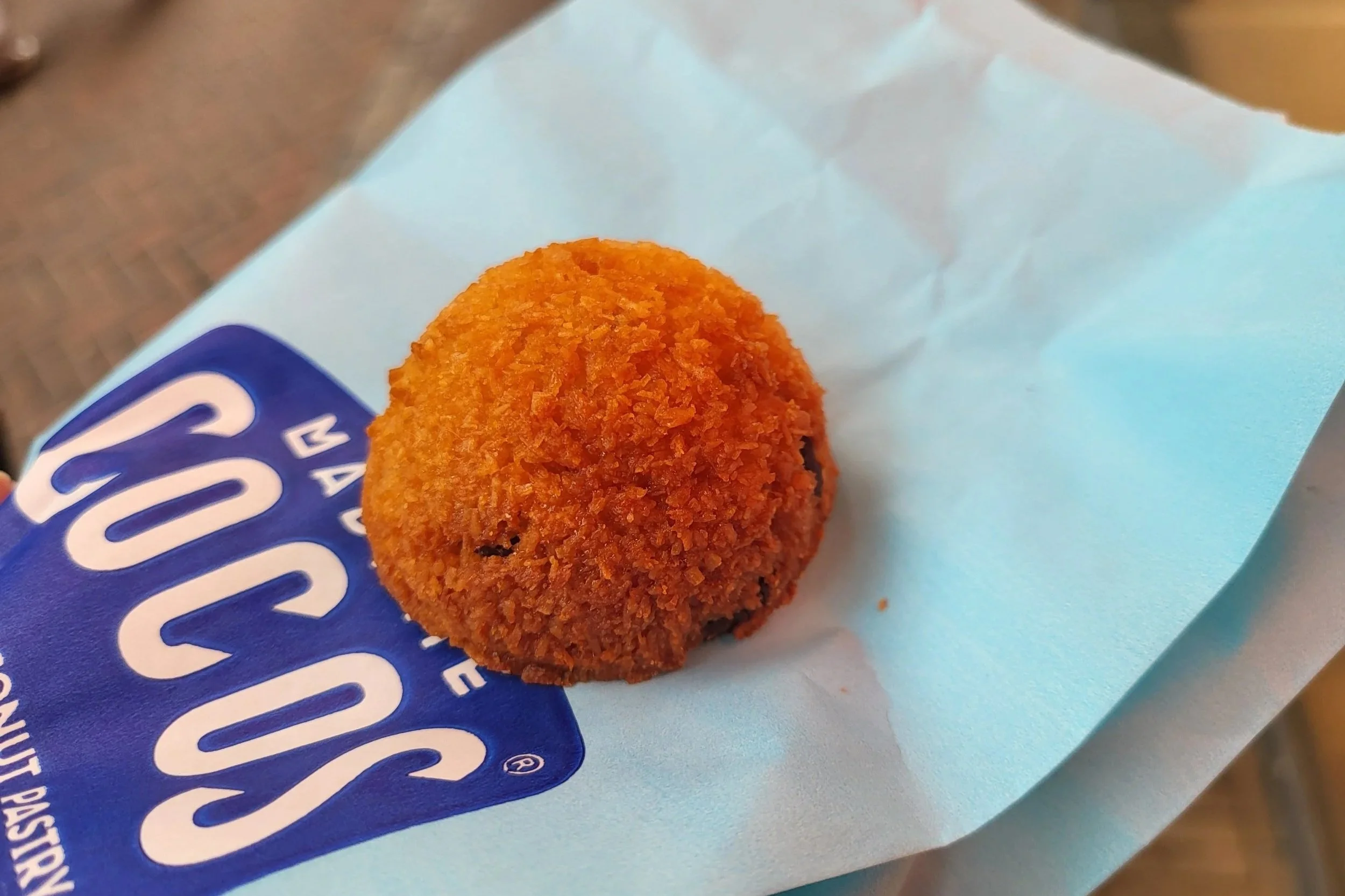 Close-up of a single gluten free coconut ball from Madame Cocos with dark chocolate