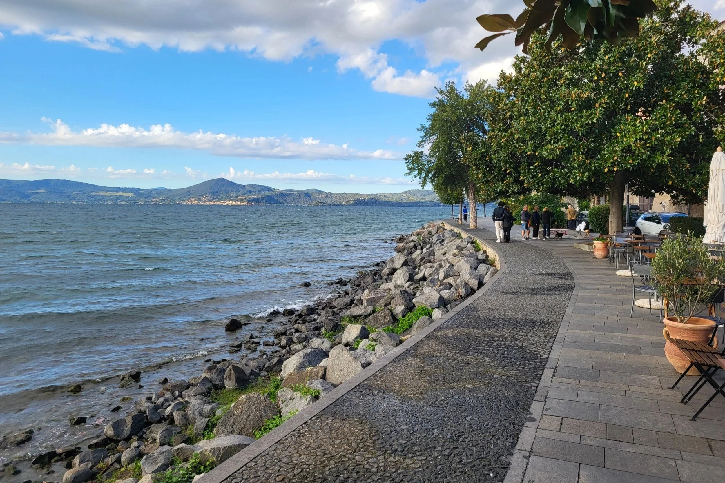 Lakeside promenade with trees and cafés along Lake Bracciano