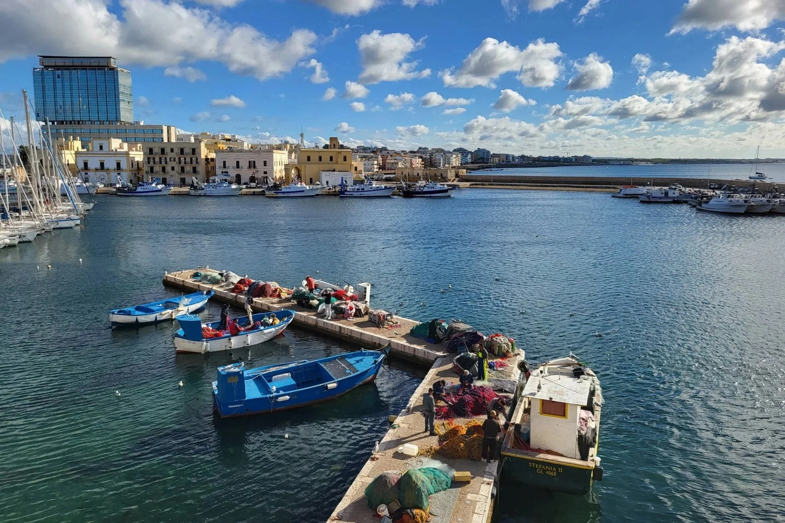 Colourful fishing boats and nets in the harbour of Gallipoli, Puglia.