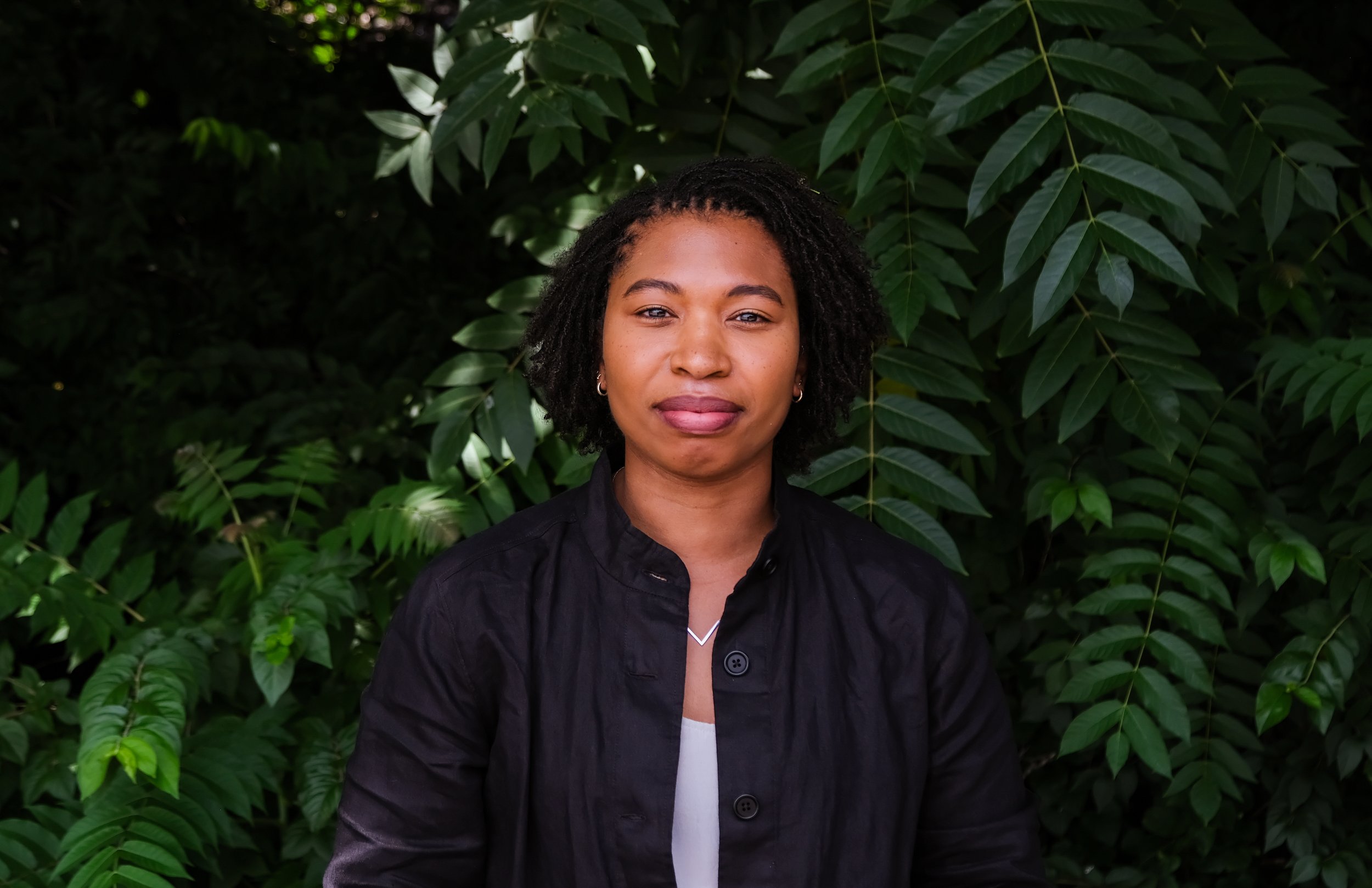 Judith is a Black woman with short micro locs and a gray jacket.