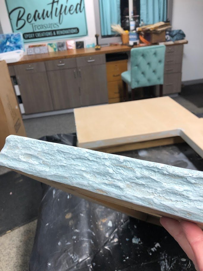 Immerse yourself in the stunning craftsmanship of our custom epoxy countertops, now enhanced with a unique rock edge effect. The edges of this countertop mimic the natural texture and appearance of stone, adding a rustic and organic feel to the sleek